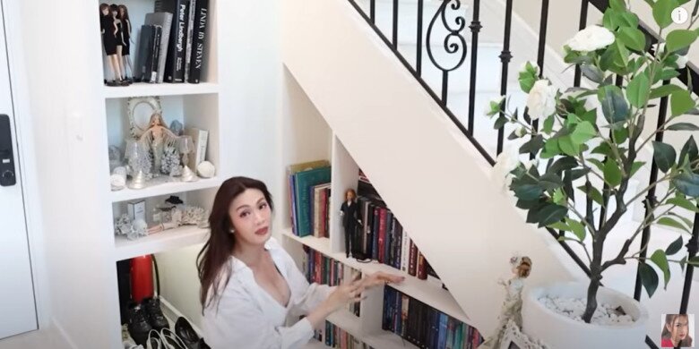 Ngay dưới cầu thang là kệ sách của Luna, cũng không thể thiếu những cô búp bê xinh xắn. Cô rất mê Trà hoa nữ nên decor một cây hoa trà bằng vải.