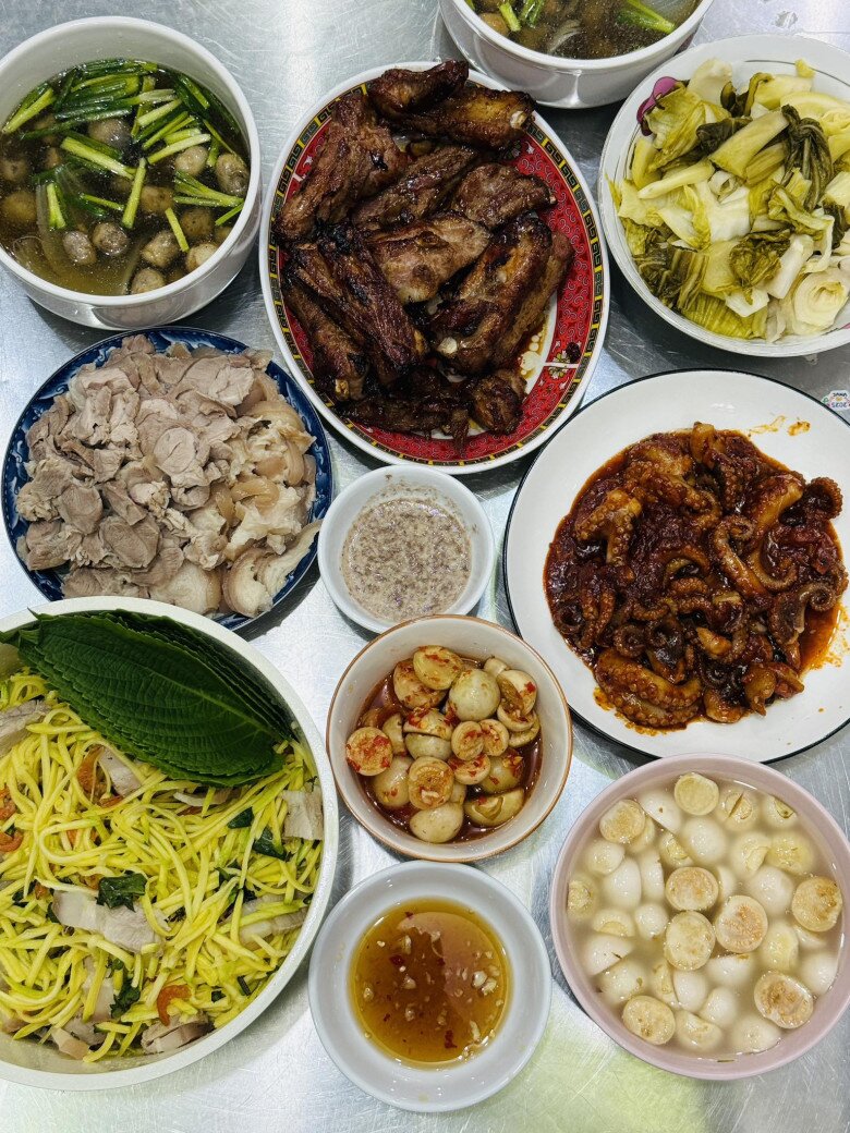 Nhìn mâm cơm mà cô gọi là “đỉnh của đỉnh”, ai cũng phải xuýt xoa vì sự đầy đặn và hấp dẫn. Có sườn nướng, thịt luộc ăn kèm mắm nêm, canh nấm thơm dịu, cải chua chống ngán, gỏi xoài thịt ba chỉ, cà muối, bạch tuộc sa tế. Những món ăn giản dị, dễ làm, nhưng chất chứa đầy tình cảm của gia đình.