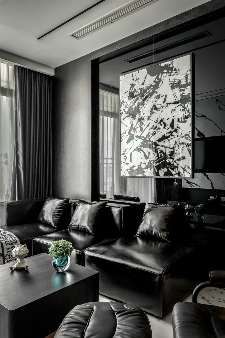 Bộ sofa da đen kết hợp ghế thư giãn tạo cảm giác sang trọng và riêng tư. Bức tranh lớn treo giữa tường như thể hiện tinh thần nghệ sĩ mạnh mẽ của gia chủ.