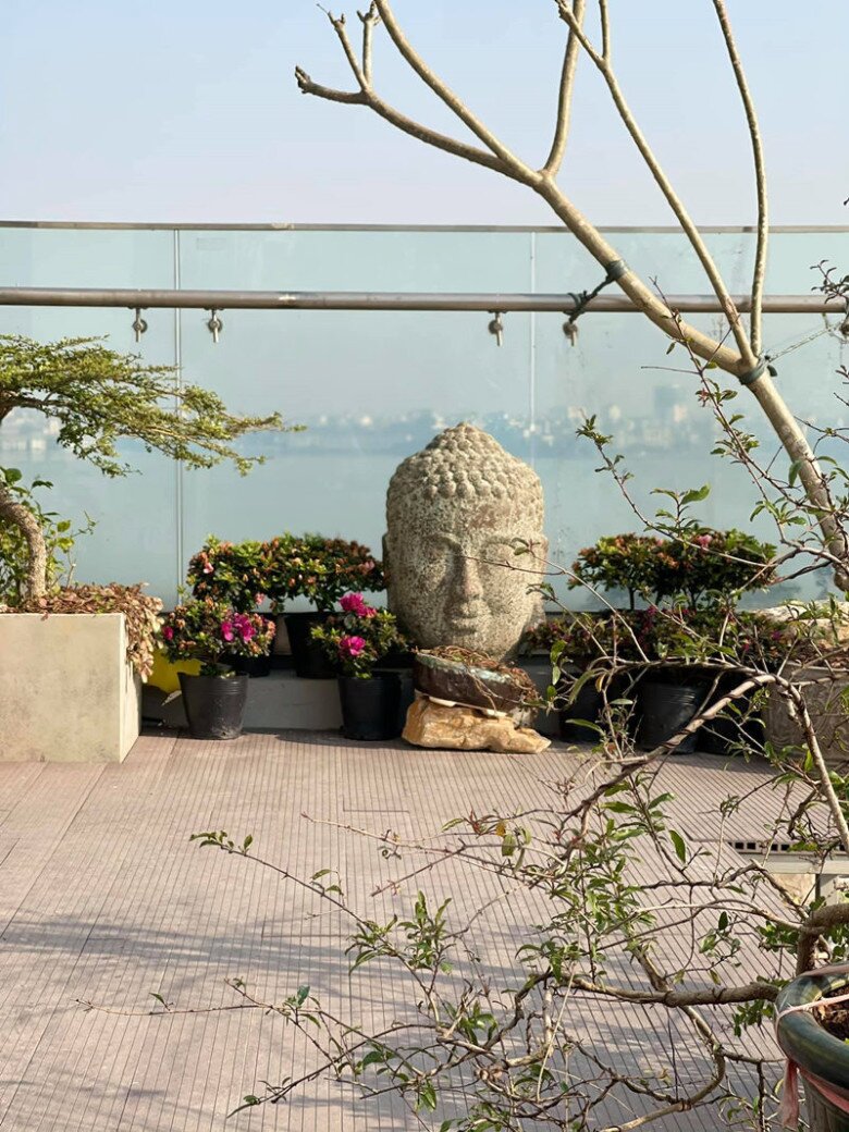 Sân thượng như một khu vườn thiền giữa khung cảnh Tây Hồ. Tượng đầu Phật đặt giữa hoa lá, bonsai, cây cảnh… tất cả tạo nên không gian thanh tịnh, nơi nam ca sĩ tìm lại sự tĩnh lặng sau những ngày biểu diễn sôi động.