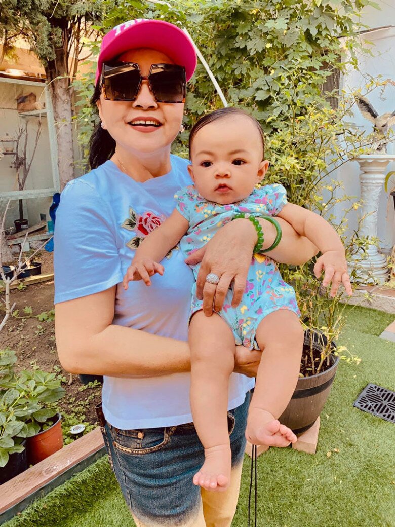 Giữa gốc bưởi sai quả, bà Hương Lan vui vẻ chụp ảnh cùng cháu ngoại. Với bà, khu vườn không chỉ là nơi thư giãn mà còn là không gian gắn kết gia đình, nơi các thế hệ cùng tận hưởng thiên nhiên.