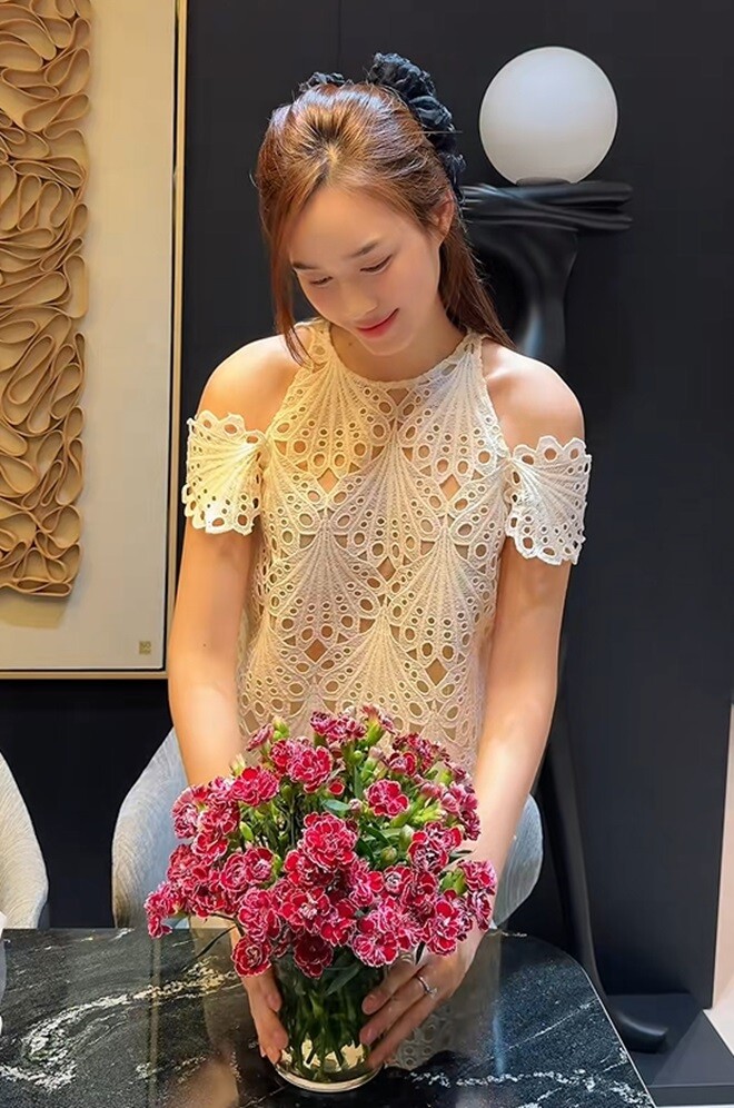 Đỗ Thị Hà tỉ mỉ với từng cành hoa, tạo dáng cho bình hoa cẩm chướng. Sự chỉn chu trong từng công đoạn cho thấy tình yêu thật sự của người đẹp với hoa.