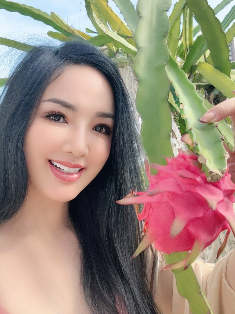 Nàng hậu không tuổi như hòa vào không khí trong lành, bên trái thanh long căng tròn. Cây cối được cô cẩn thận uốn theo đường viền giàn, tạo nên một khu vườn trên cao vừa duyên dáng vừa gọn gàng.