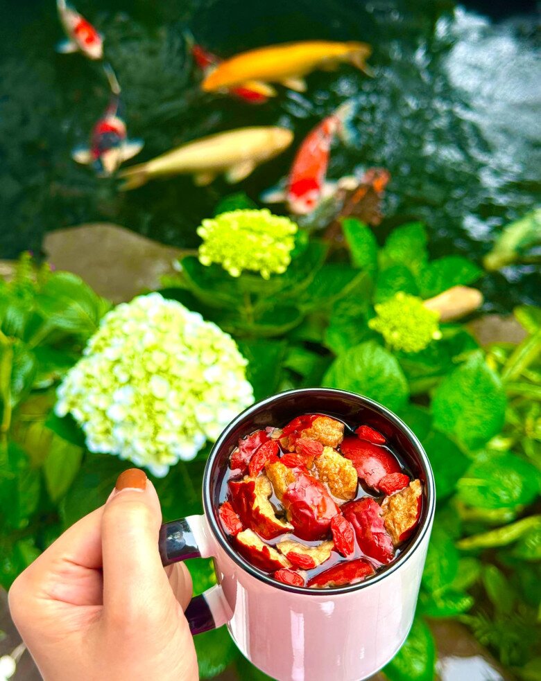Lã Thanh Huyền thư thả nâng ly trà thảo mộc, ngắm đàn cá koi uốn lượn và hoa cẩm tú cầu khoe sắc. Khoảnh khắc thư thái, giúp cô kết nối sâu sắc với thiên nhiên.