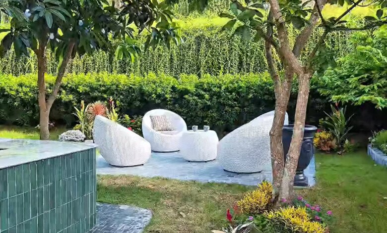 Nhìn từ góc khác, khu vực thư giãn nép mình dưới tán cây lớn, mang lại cảm giác mát mẻ và riêng tư.
