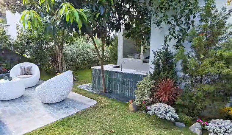 Bồn rửa tay lát gạch men xanh đặt cạnh khu tiếp khách, tiện lợi mà vẫn tinh tế giữa khu vườn xanh mát.