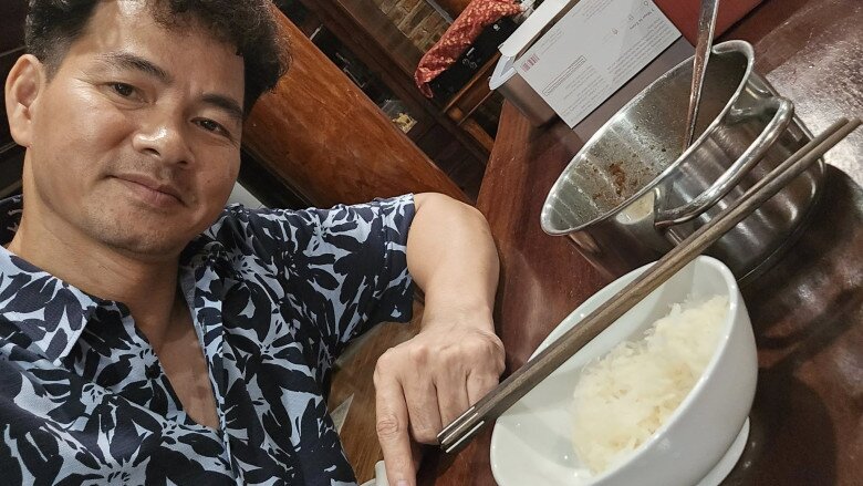 NSND Xuân Bắc tươi cười bên “bữa khuya huyền thoại”. Dù là nửa đêm, anh vẫn rạng rỡ bên nồi mắm tép và bát cơm nguội, vẻ hài lòng hiện rõ trên gương mặt khiến ai cũng thấy ấm lòng.