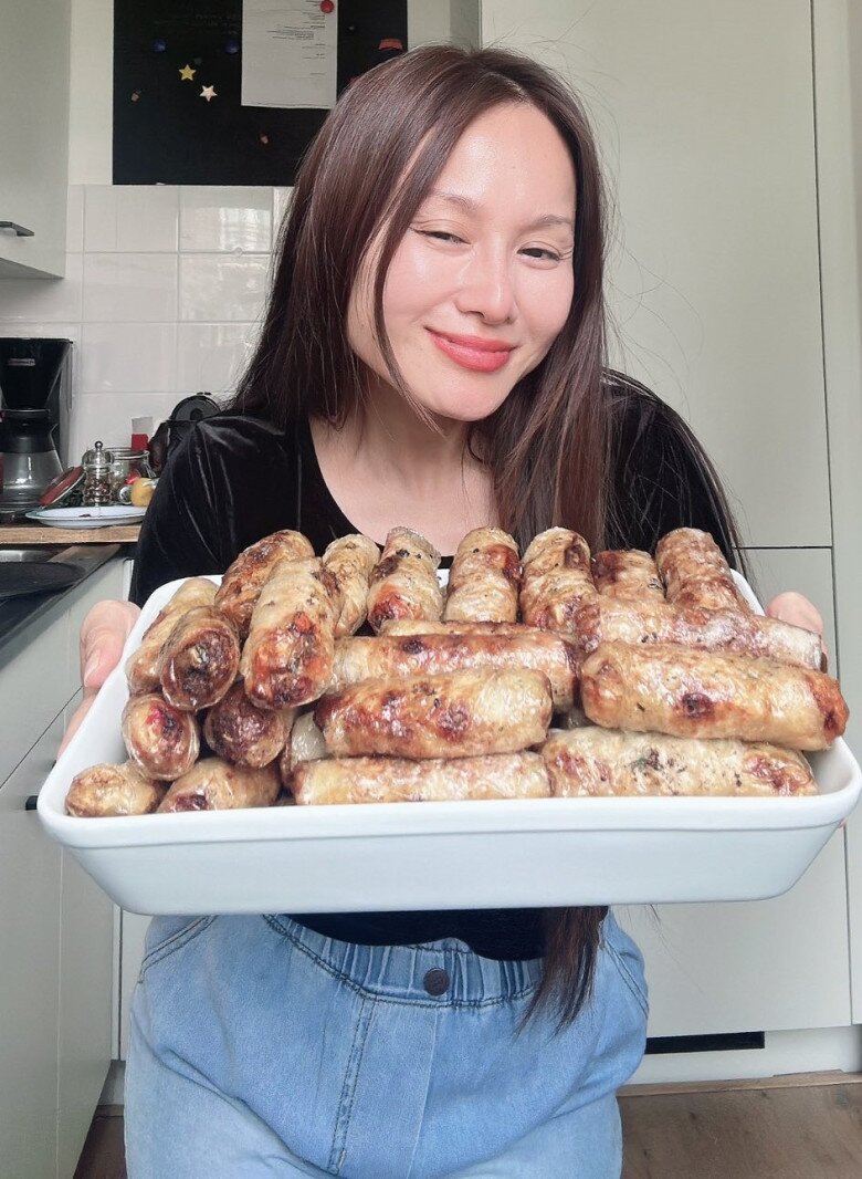 Nữ ca sĩ hạnh phúc bên khay nem mà mình đã cất công chuẩn bị, ánh mắt cô ánh lên niềm vui của người giữ lửa gia đình, của người con xa quê gửi gắm tình yêu quê hương qua món ăn thân thuộc.