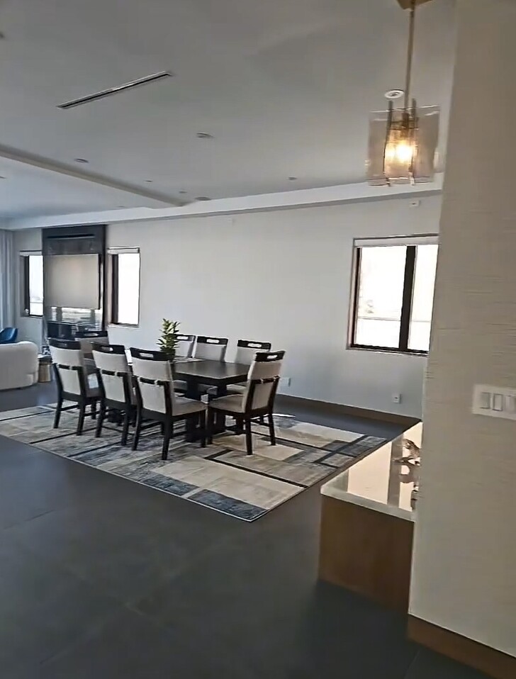  Góc bàn ăn trang nhã với thảm lót sàn kẻ và đèn thả trần tối giản. Phù hợp với những buổi tiệc gia đình ấm cúng hoặc tiếp bạn bè thân thiết như Như Ý chia sẻ trong clip.