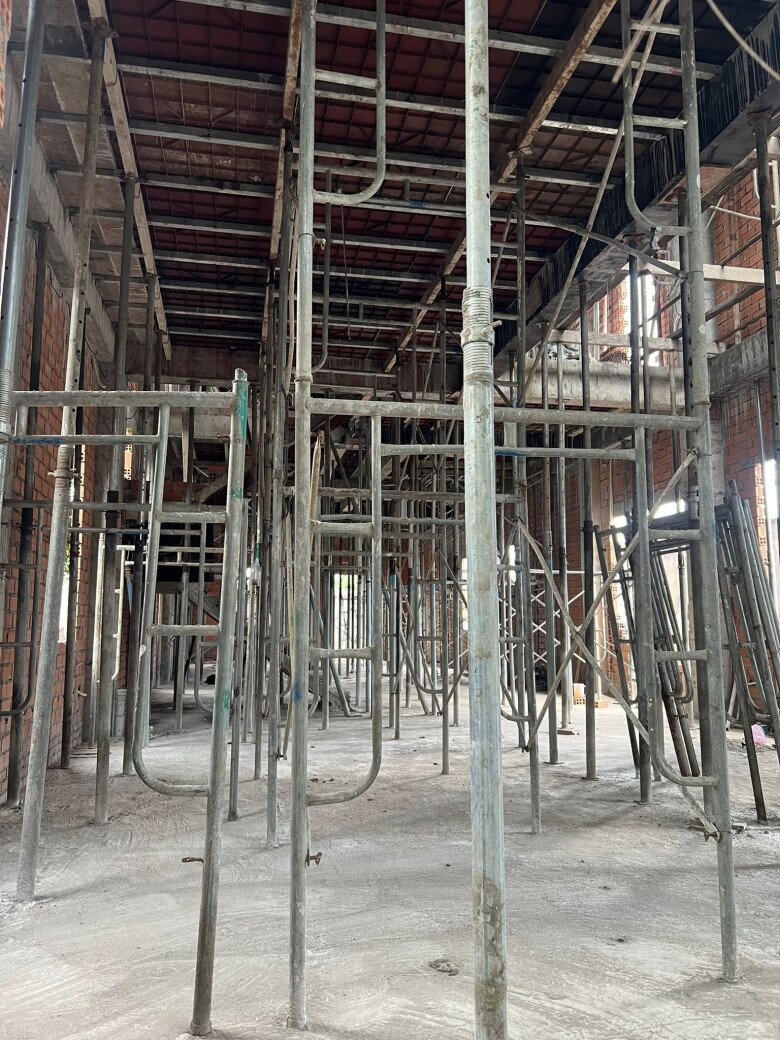 Không gian bên trong trông rất rộng. Hệ thống giàn giáo dày đặc phục vụ thi công trần bê tông. Mặt sàn đã được đổ bê tông phẳng, chuẩn bị cho giai đoạn lát nền.