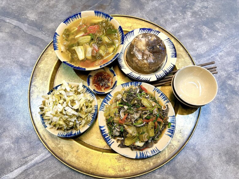 Một mâm cơm cực kỳ dân dã, nào bắp cải muối, nào canh dưa, lòng xào dưa rắc hạt tiêu, thịt đông núng nính đủ để anh gọi là “đặc sản”.