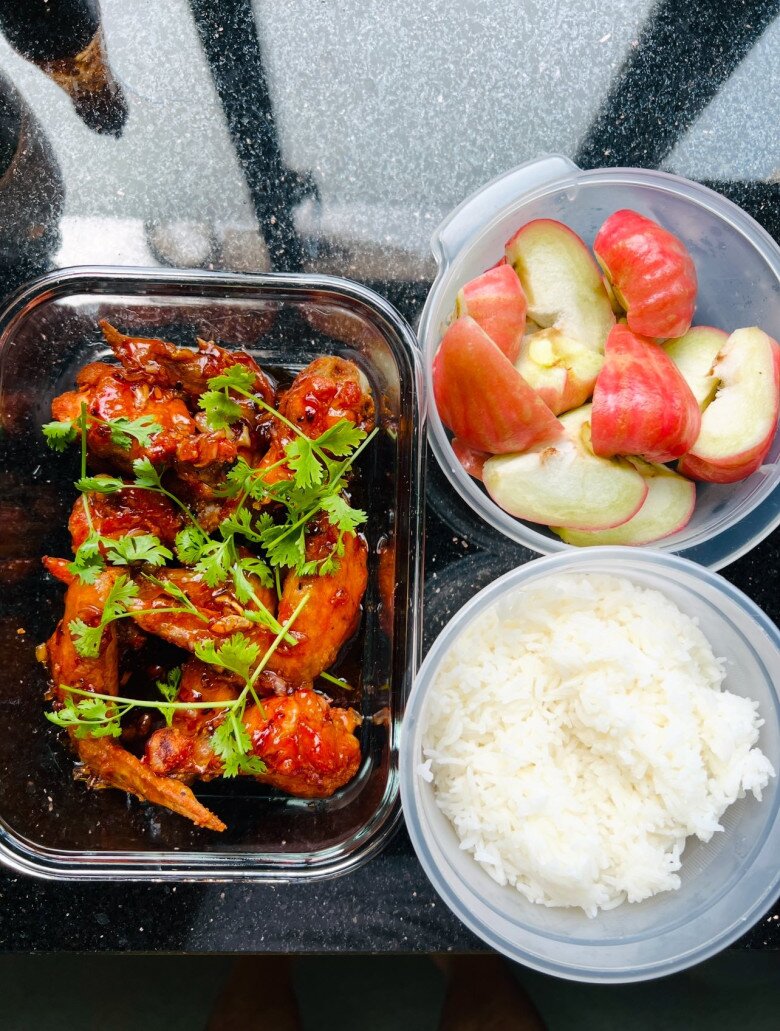 Một bữa cơm trưa ấm cúng gồm cánh gà chiên nước mắm vàng ruộm, phủ rau mùi tươi, ăn kèm cơm trắng dẻo và trái cây tráng miệng. Món ăn vừa đậm đà, vừa có đầy đủ dinh dưỡng.