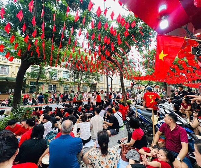 Bà con ngồi rất đông phía trước cửa hàng để chờ xem diễu binh