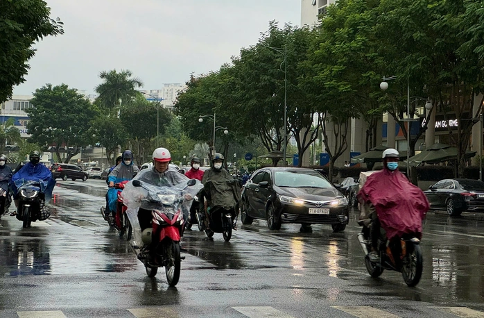 Người dân di chuyển trong cơn mưa kéo dài ở TP HCM