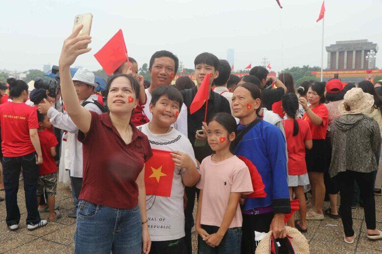 Bà Nón trong bộ trang phục truyền thống chụp ảnh lưu niệm cùng mọi người