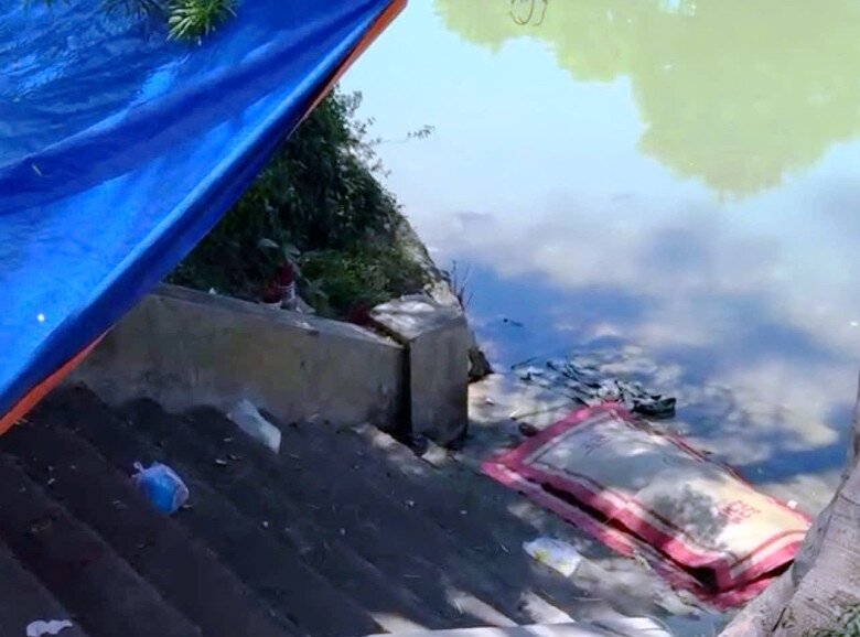 Thi thể người đàn ông được đưa tạm vào bờ sau khi người dân phát hiện nổi trên sông An Cựu.