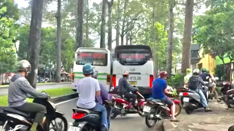 Hai xe khách chắn ngang đường khiến nhiều xe máy phải chạy lên vỉa hè để di chuyển. Ảnh: NT