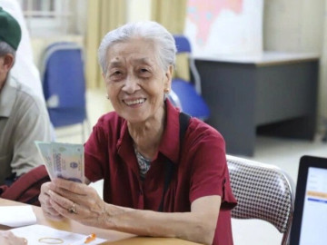 Người già không có lương hưu phấn khởi khi được nhận trợ cấp