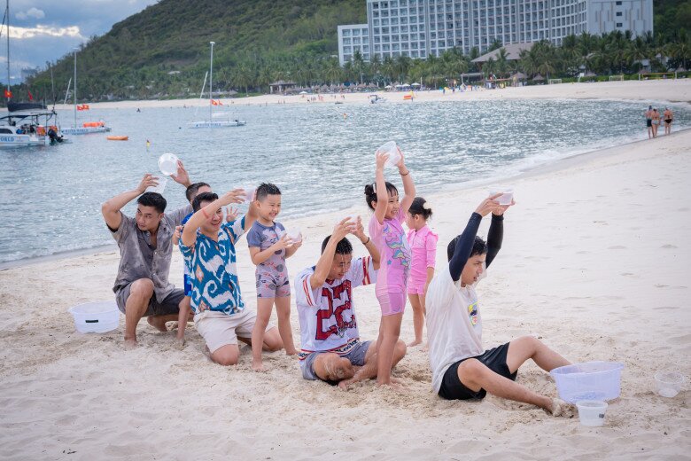 Các cặp bố con thích thú tận hưởng mùa hè đầy sôi động, vui tươi ở biển.