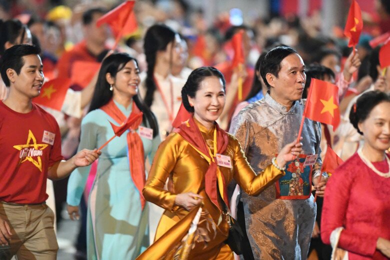 Vợ chồng NSND Lan Hương và NSƯT Đỗ Kỷ hòa vào dòng người trong khối diễu hành. Cặp đôi nghệ sĩ gạo cội từng có kinh nghiệm tham gia diễu hành vào những dịp đại lễ trước đây.