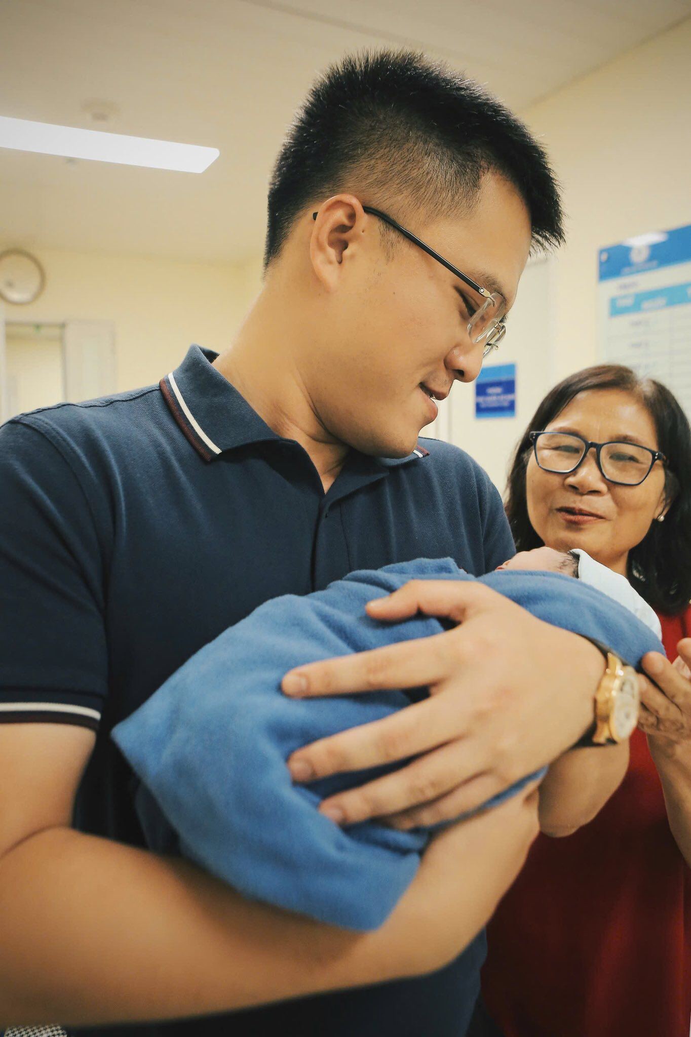 Ông xã và mẹ ruột nàng hậu hạnh phúc nhìn em bé mới chào đời.