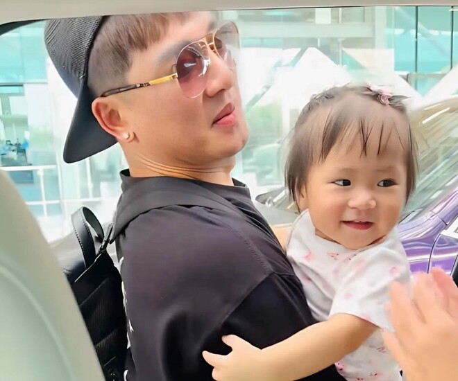 Con gái Châu Khải Phong được bố bế thì tươi cười.