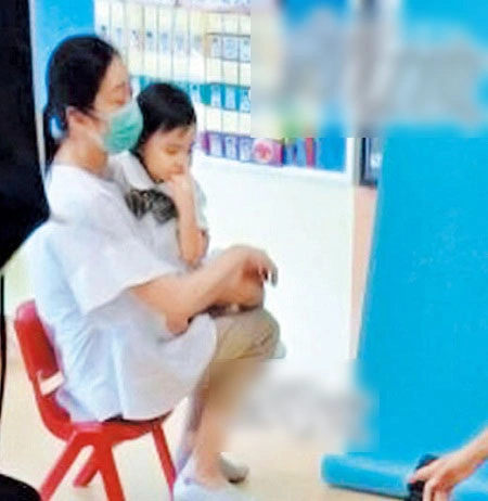 Vợ chồng Lưu Đức Hoa ngồi xếp hàng chờ nhập học cho con gái.