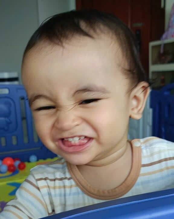 Cậu nhóc đã có vài chiếc răng cửa nên càng cười càng xinh, càng đáng yêu.
