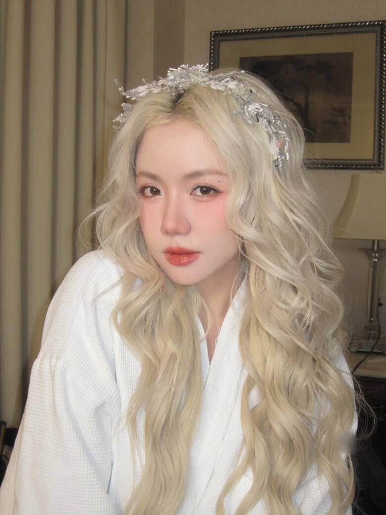 Với mái tóc bạch kim xoăn sóng, vương miện ngọc trai và makeup hồng đào, Phương Ly lột xác thành một nàng tiên cổ tích giữa đời thực. Kiểu tóc bồng bềnh, làn da trắng sứ càng khiến tổng thể trở nên mơ màng như bước ra từ MV Hàn Quốc.