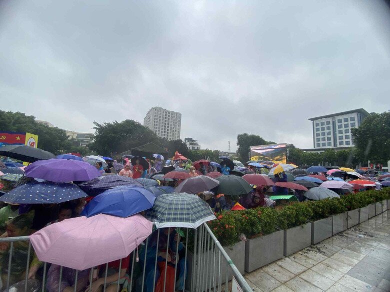 Khoảng 9h sáng, trời mưa lớn người dân vẫn đội ô, mặc áo mưa để chờ đợi xem diễu binh 