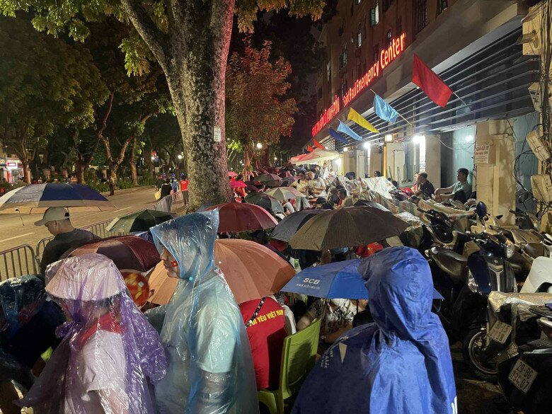 Tại đường Trần Phú, dù trời có mưa nhưng người dân vẫn vui vẻ chờ đợi 