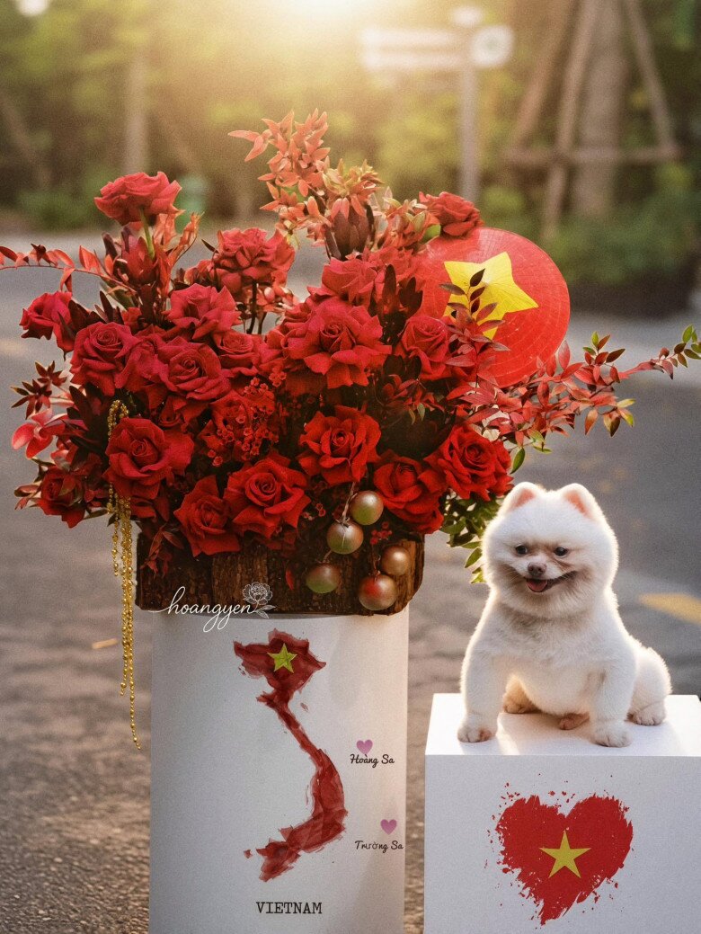 Giỏ hoa rực rỡ sắc đỏ với chiếc nón lá thân thương, bản đồ Việt Nam trên bục đặt hoa được chị Hoàng Yến thiết kế đầy tâm huyết, bên cạnh là chú chó nhỏ dễ thương như góp vui chào mừng ngày 2/9.