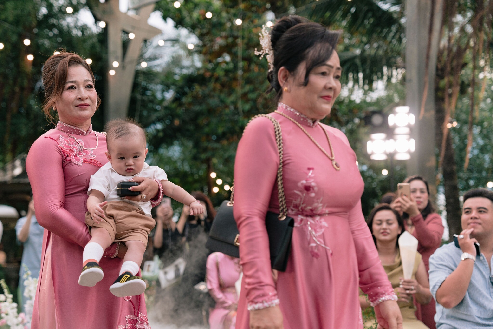 Bé Hin được bà ngoại bế lên lễ đường.