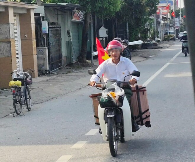 Cụ Thanh xuất phát từ Nghệ An lúc 8h sáng nay 21/8 bằng chiếc xe máy cũ, phía sau có vali màu hồng và lá cờ đỏ sao vàng tung bay (Ảnh: MXH)
