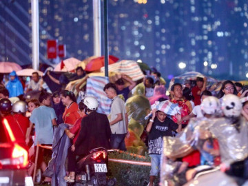 Mưa lớn bất chợt, người dân TPHCM chờ xem pháo hoa phải di chuyển