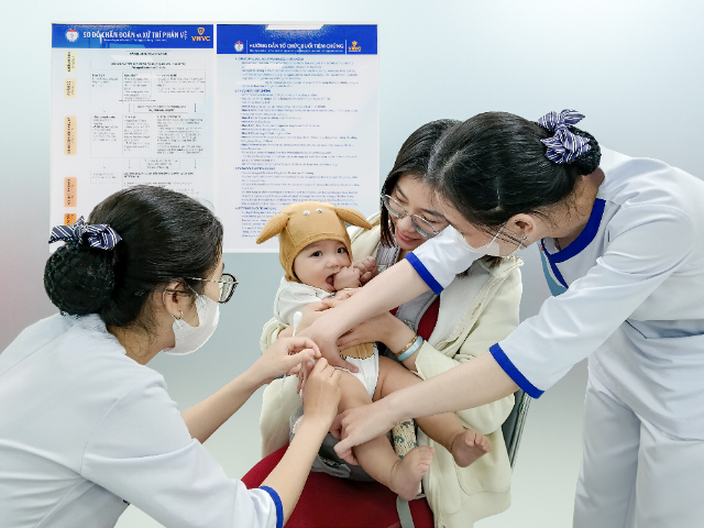 Phụ huynh đưa trẻ đi tiêm vắc xin phòng bệnh tại Hệ thống Tiêm chủng VNVC. Ảnh: Mộc Thảo