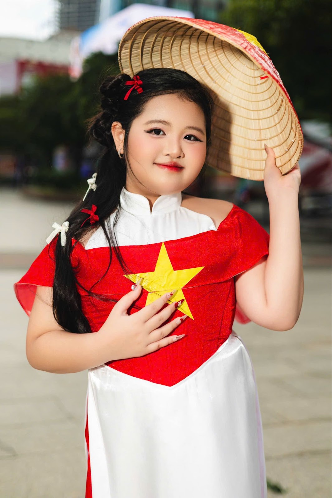 Thiết kế áo dài lấy cảm hứng từ quốc kỳ kết hợp cùng phụ kiện nón lá, quạt đỏ in chữ “Việt Nam” giúp Dory Như toả sáng. 