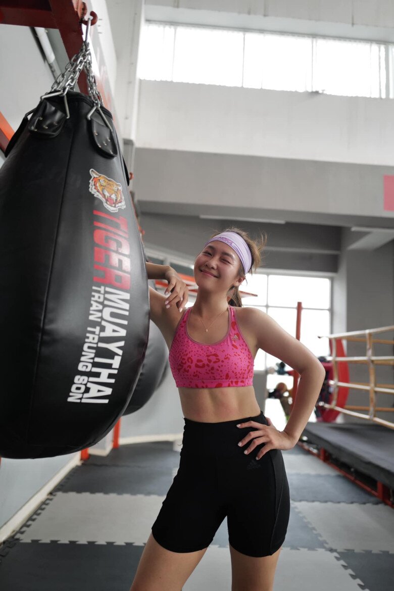 Bức ảnh trong phòng tập boxing chính là sự gợi nhớ đến giai đoạn đầu của Khả Ngân – nàng hot girl boxing từng nổi lên nhờ hình ảnh khỏe khoắn, tràn đầy năng lượng. Nhưng giờ đây, thay vì chỉ đơn giản là một “gương mặt xinh đẹp chơi thể thao”, Khả Ngân toát lên thần thái của một người phụ nữ biết chăm sóc bản thân, yêu cơ thể và tự tin thể hiện chính mình. Chiếc bra hồng ôm sát khoe body săn chắc, vòng eo thon gọn càng tôn thêm sự tự hào cho hành trình lột xác ngoạn mục của cô.