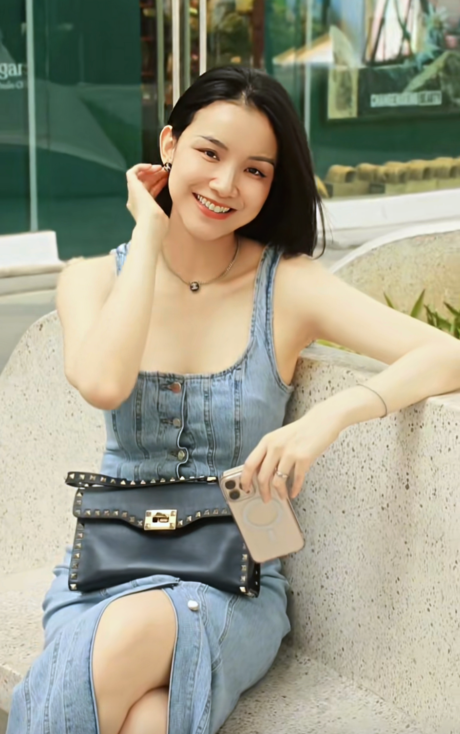 Thùy Lâm chọn váy denim hai dây dáng ôm với hàng cúc phía trước, kết hợp túi xách đen đính đinh tán và trang sức tối giản. Hoa hậu thường để kiểu tóc xõa tự nhiên, kết hợp lớp trang điểm trong trẻo.