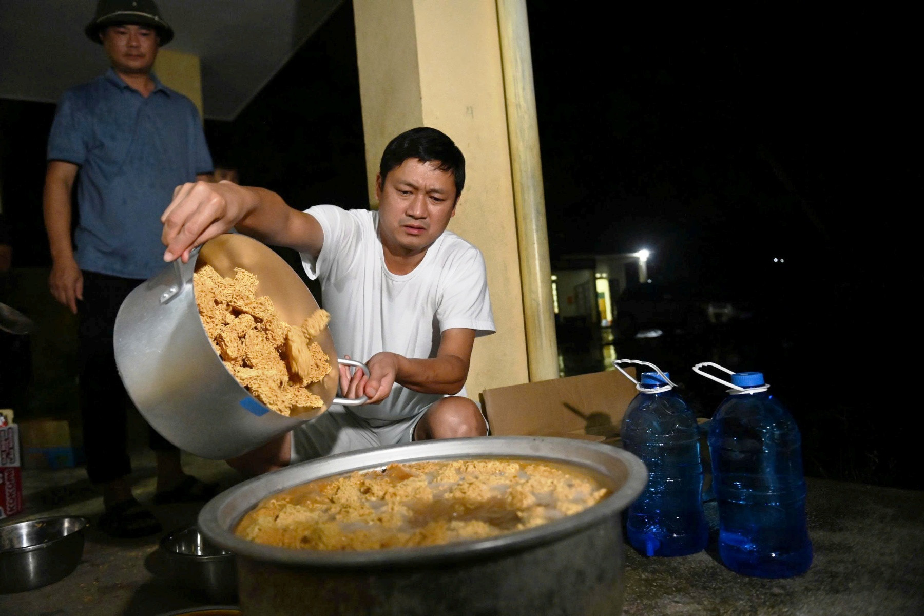 Trong đêm, ông Hoàng Văn Huân (áo trắng), Chủ tịch UBND xã Mường Khoa (Lai Châu) cùng hơn 20 cán bộ địa phương đi hơn 30km đến hỗ trợ bà con vùng lũ. Ảnh: H.L