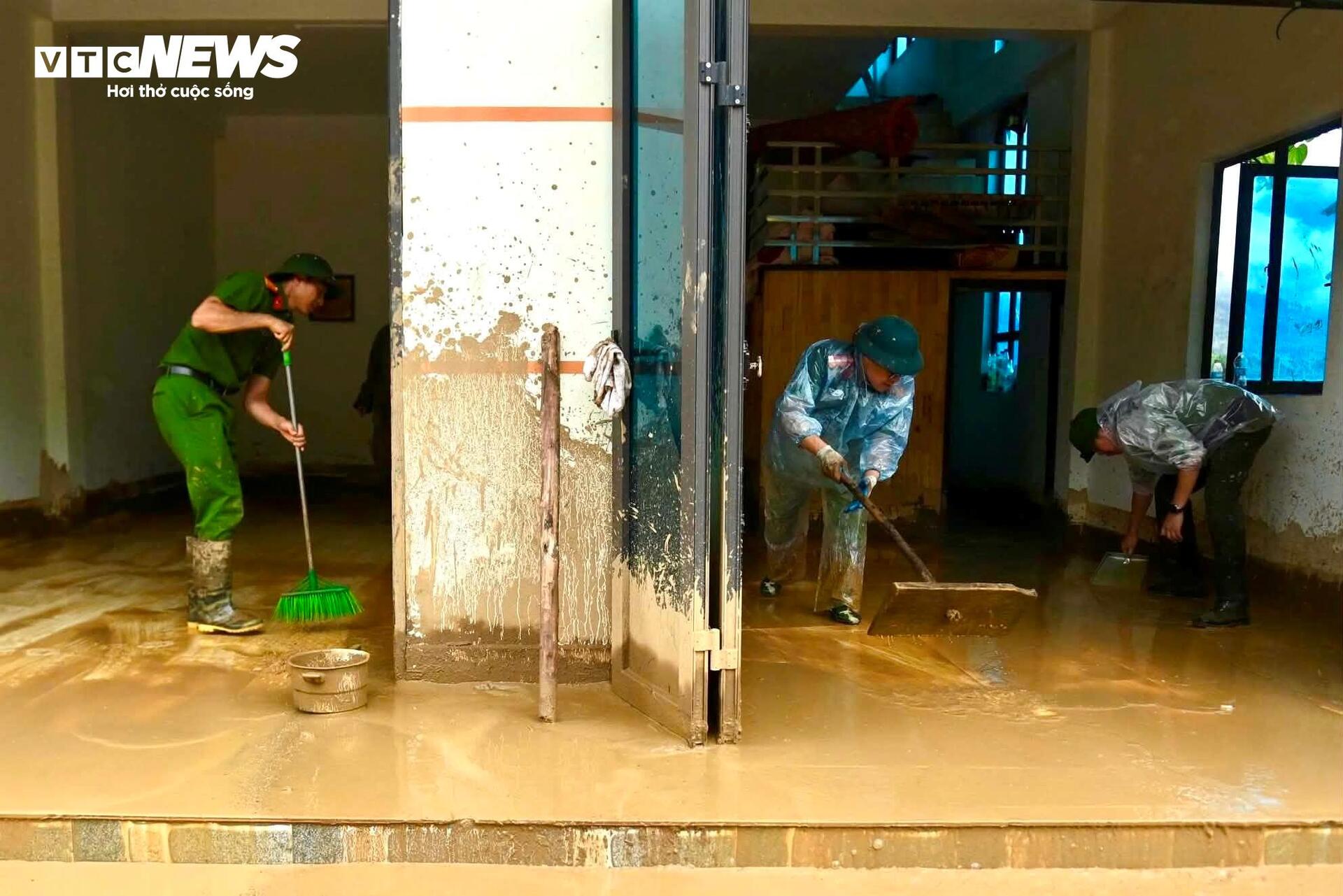 Người cầm xẻng, người cầm chổi, người hợp sức đẩy từng tấm ván, khẩn trương dọn lớp bùn đất dày đặc phủ kín nền nhà.