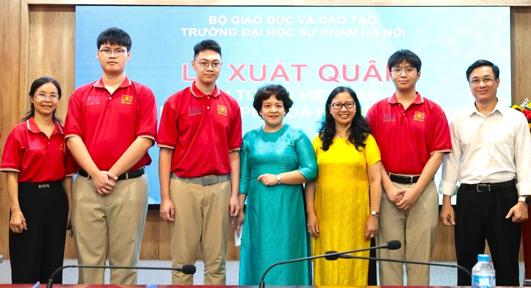 Bà Trần Thùy Dương, Hiệu trưởng Trường THPT chuyên Hà Nội - Amsterdam (áo xanh), cô Lê Thị Ngọc Hà (ngoài cùng bên trái) cùng các thầy cô trong trường bên 3 chàng trai lớp 12 Hóa 1.