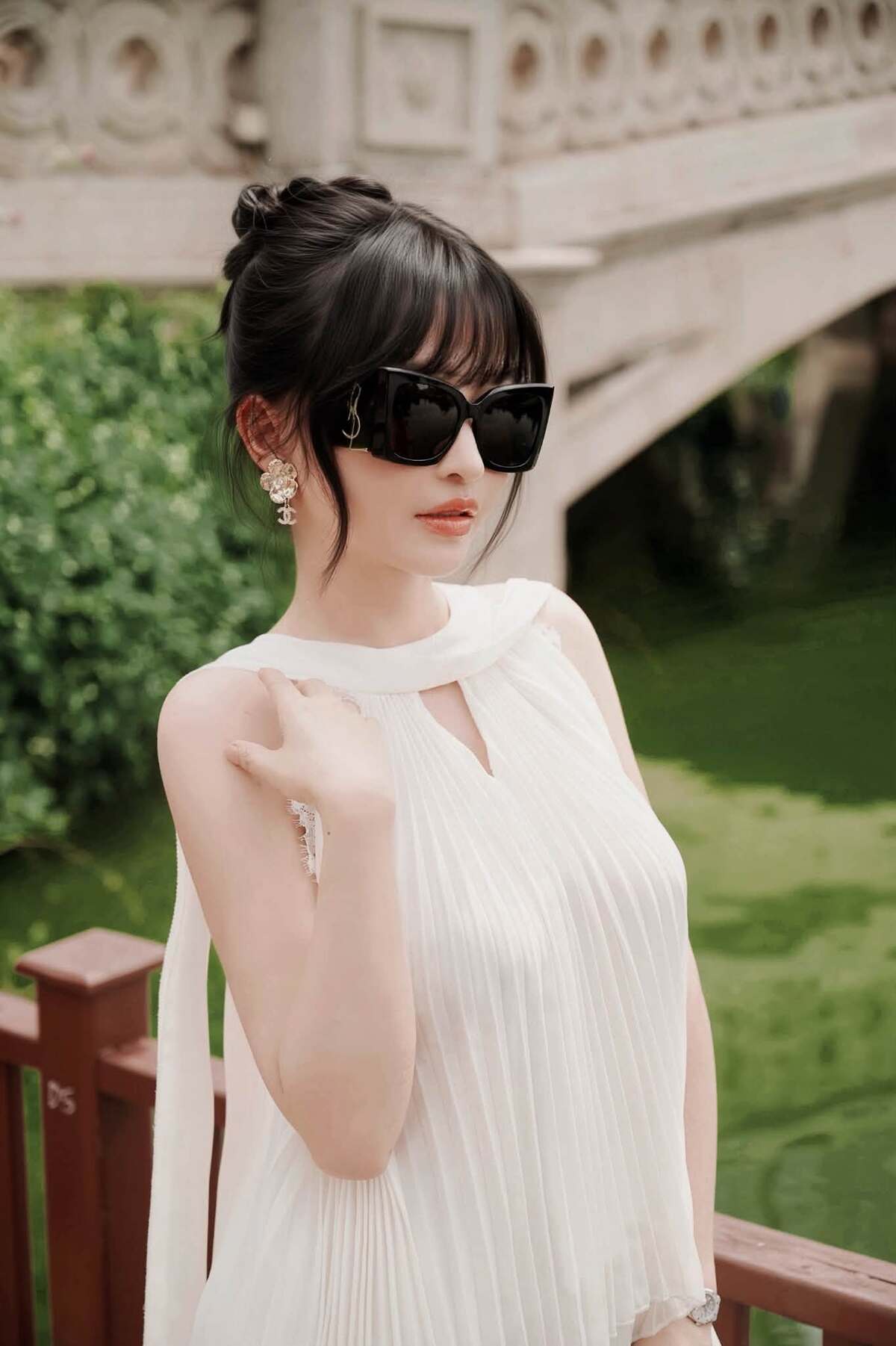 Bà xã đại gia Minh Nhựa tạo điểm nhấn cho phong cách bằng bông tai Chanel, kính râm Saint Laurent và túi Hermes Kelly da cá sấu khoảng 45.000 USD (gần 1,2 tỷ đồng).
