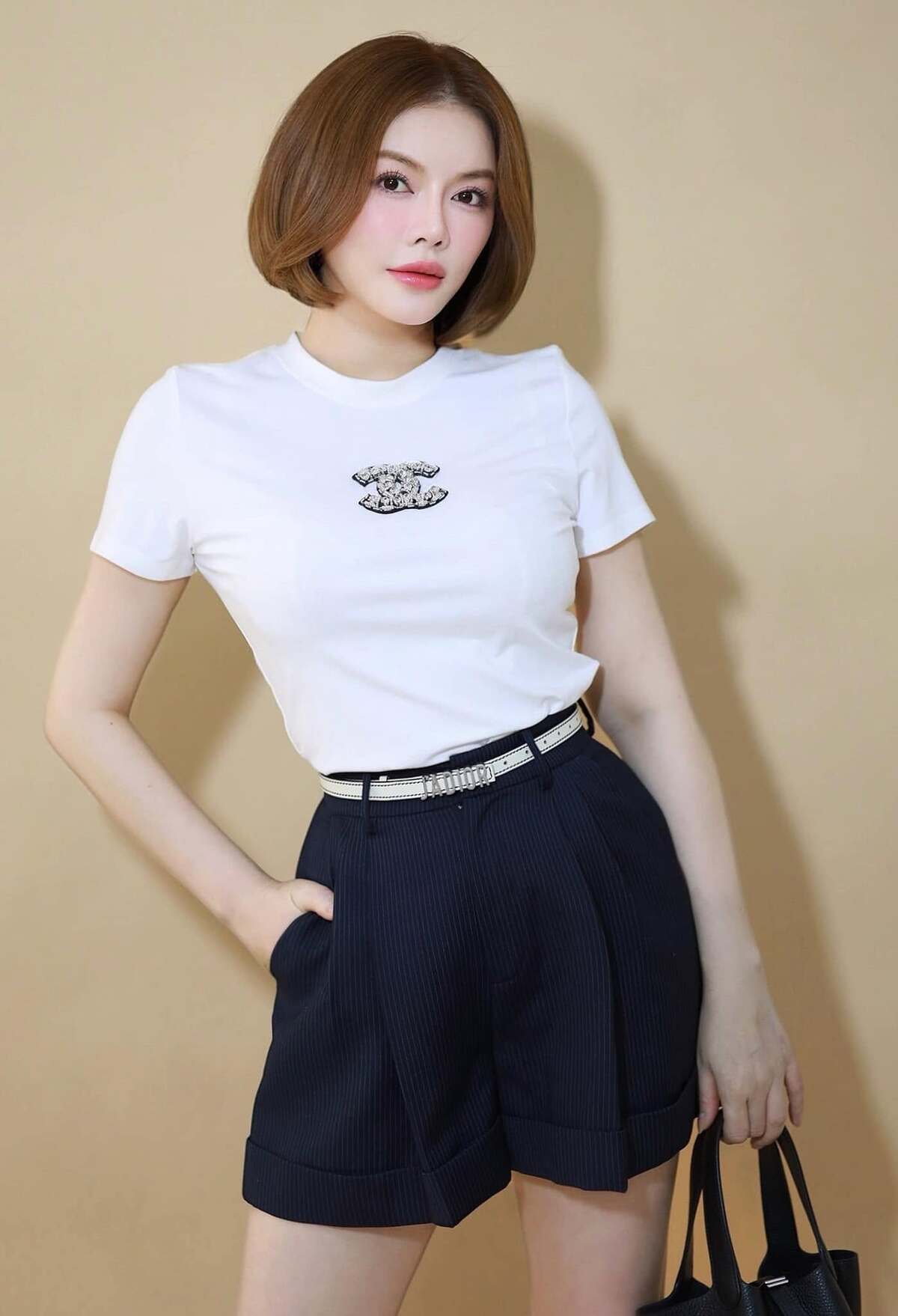 Phong cách công sở thanh lịch với quần lửng xếp ly, áo phông Chanel. So với những bộ suit hay đầm midi, kiểu mặc này giúp người mặc trông tươi trẻ hơn.