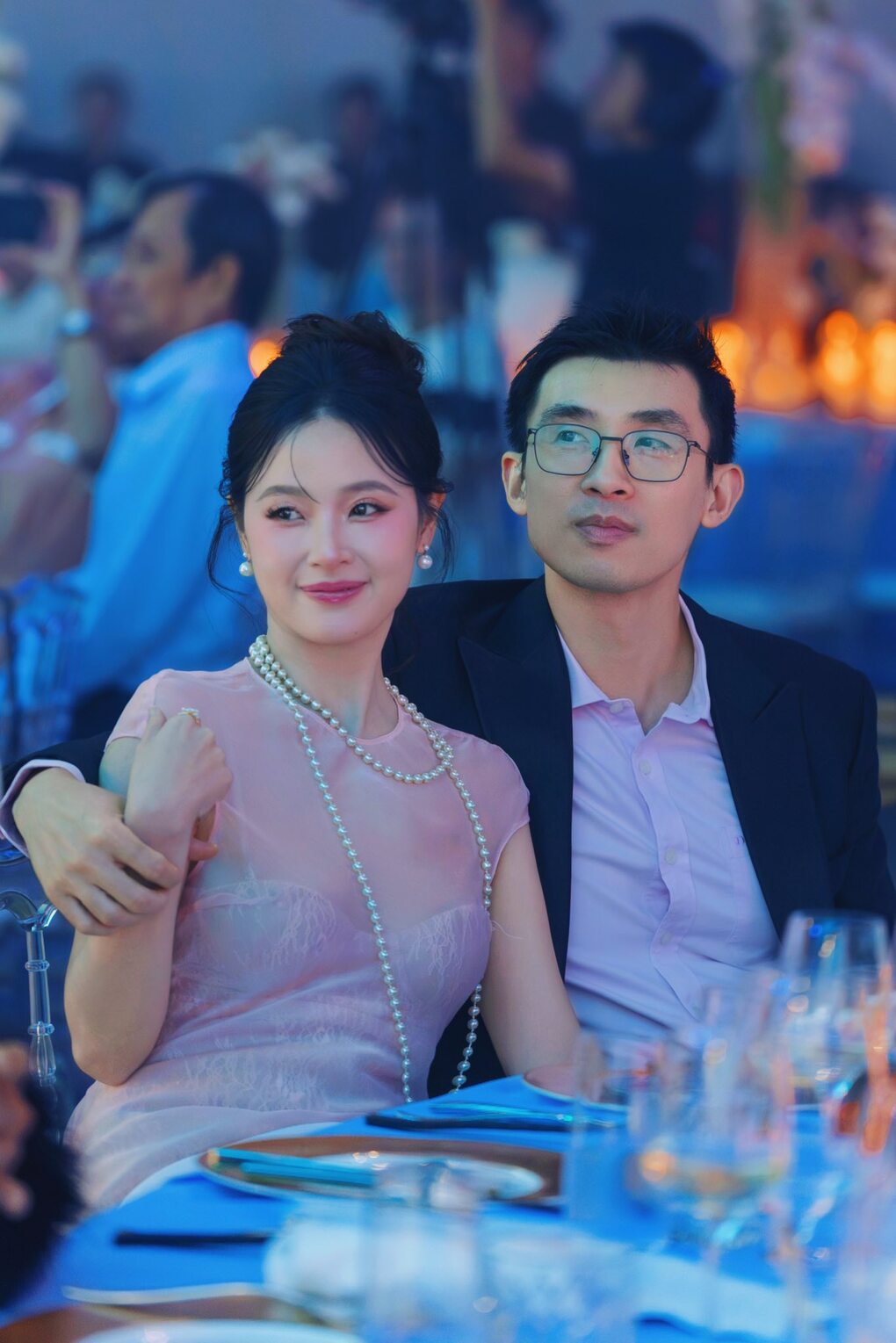 Trong khi Midu diện đầm phối voan xuyên thấu tông hồng pastel để tôn da trắng, Minh Đạt khéo chọn chiếc sơ mi hồng nhạt ăn nhập cùng trang phục của vợ. Bộ đồ giúp họ được khen trông thanh lịch.