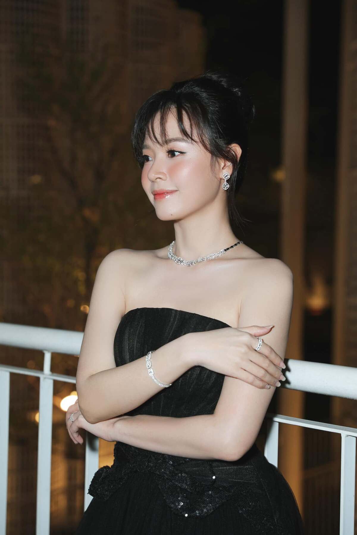 Cô đeo bộ trang sức lấp lánh, búi tóc cao.