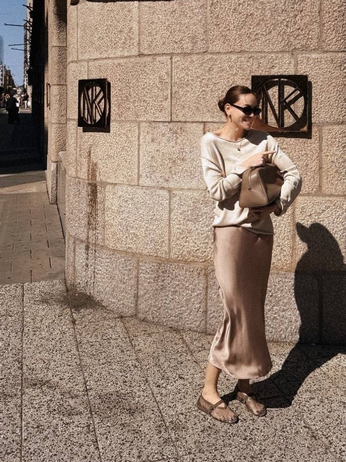 Hồ Ngọc Hà dạo phố phường Barcelona, Tây Ban Nha với áo dệt kim cùng chân váy lụa gam nâu - be. Tất cả theo phong cách quiet luxury mà cô yêu thích.