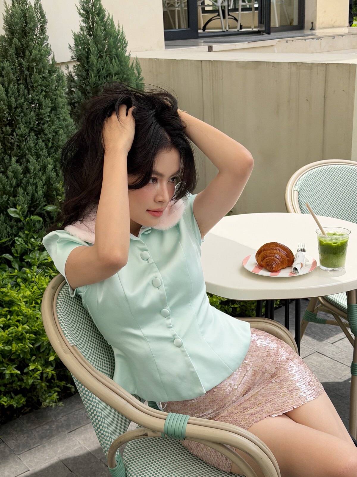 Hôm 23/7, Hoàng Thùy Linh chia sẻ gu thời trang đường phố khi đi cà phê. Cô phối áo lụa satin xanh bạc hà hơn 700.000 đồng với chân váy sequin hồng pastel.