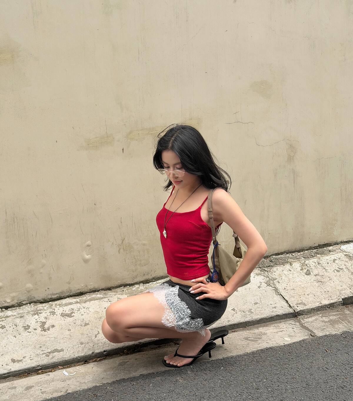 Hoàng Thùy Linh phối áo hai dây cùng chân váy đắp ren - một trong những mốt hot nhất mùa hè năm nay. Cô kết hợp cặp kính giả cận, tạo thành bộ cánh theo phong cách mọt sách gợi cảm.