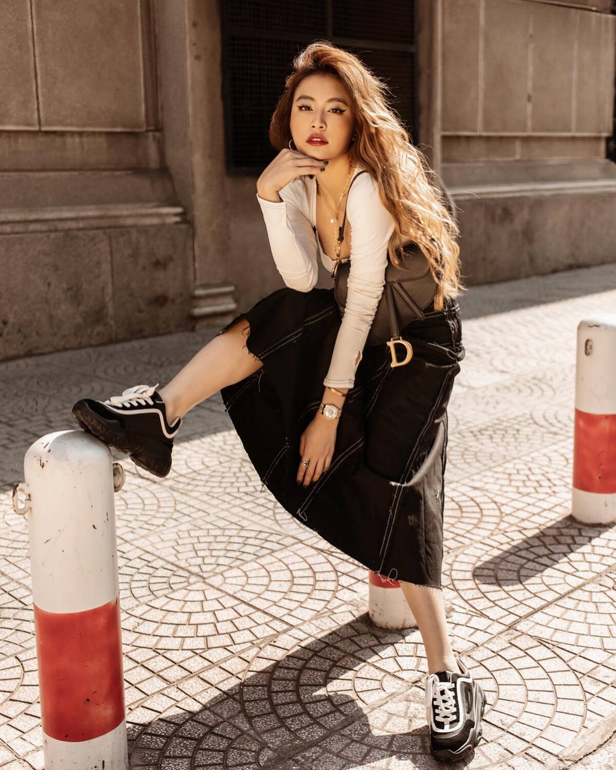 Phong cách urban chic thông qua bộ cánh đơn sắc gồm áo thun dài tay, chân váy denim và sneakers, nhấn bằng túi Dior.